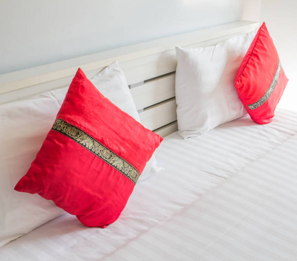 Modern bedroom double of red cushions and white pillows on white bed 3610 stock pictures, royalty-free photos & images