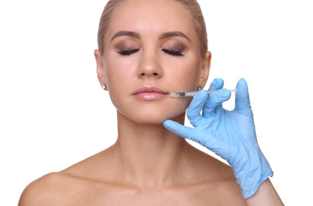 istock Beautiful woman gets an injection in her lips 815681694