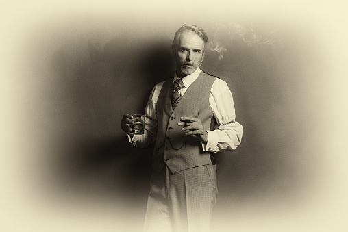 Antique plate photo of vintage businessman 1920s style smoking cigar and holding glass of whiskey.
