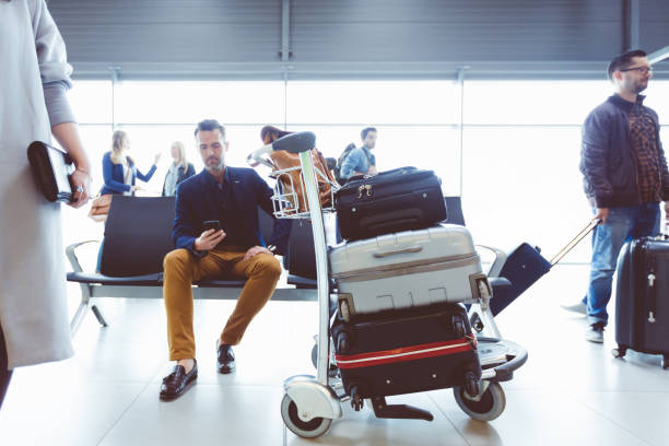 reifer mann warten am flughafen-lounge - luggage cart stock-fotos und bilder