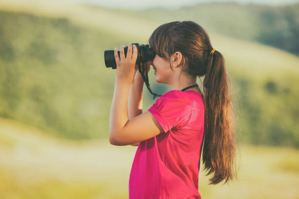 istock Little girl using binoculars in the nature 815695980