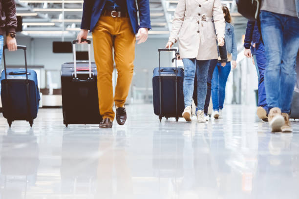istock Passengers walking in the airport corridor with luggage 815695988