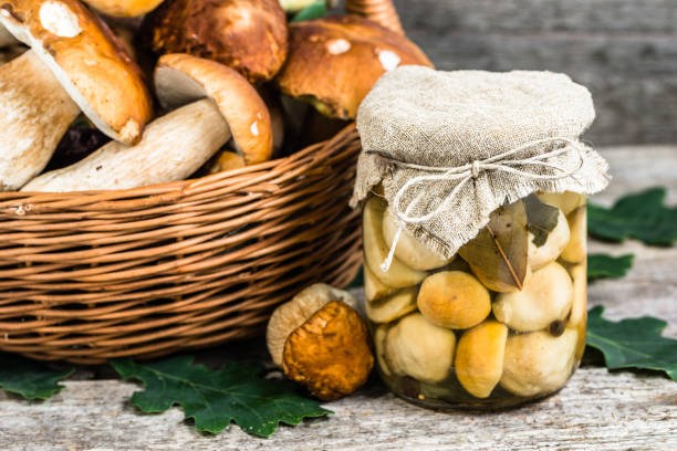 istock Marinated mushrooms - boletus pickled in jar on rustic table, preserves preparing 815699460