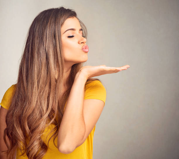 I have nothing but love for you Closeup of an expressive young woman against a grey background blowing a kiss stock pictures, royalty-free photos & images