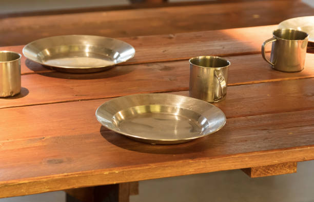 istock Very old metal cups and plates on a wooden table 815708530