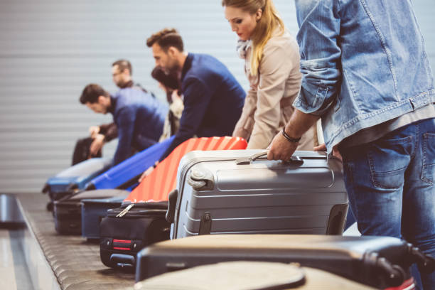 istock Travelers picking their luggage from conveyor belt 815708534