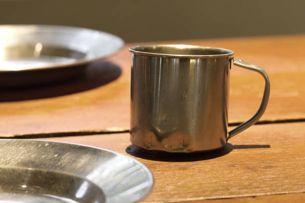 istock Very old metal cups and plates on a wooden table 815708596
