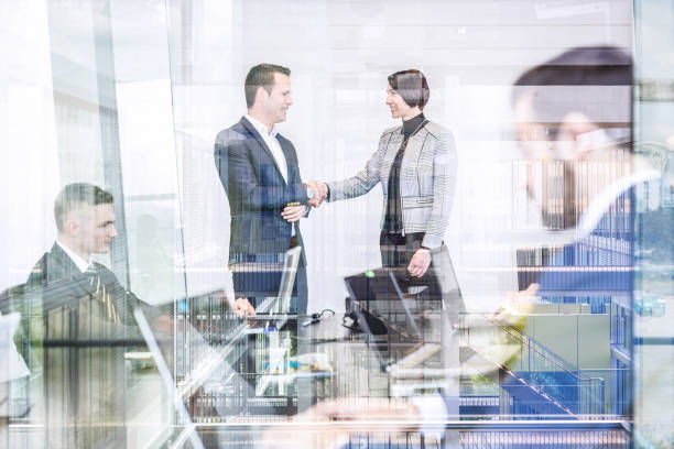 istock Business people shaking hands in moder corporate office. 815711420