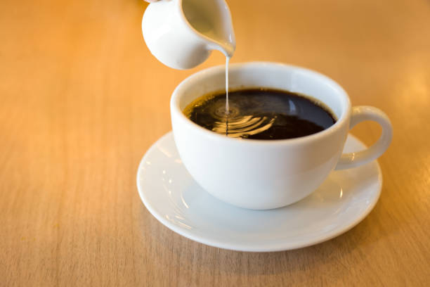 istock Pouring condensed milk into the coffee. 815717168