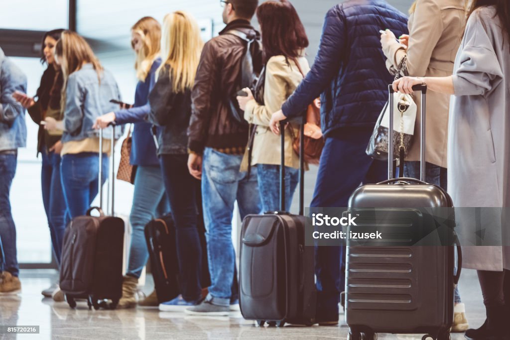 Group of people standing in queue at boarding gate Shot of queue of passengers waiting at boarding gate at airport. Group of people standing in queue to board airplane. Airport Stock Photo