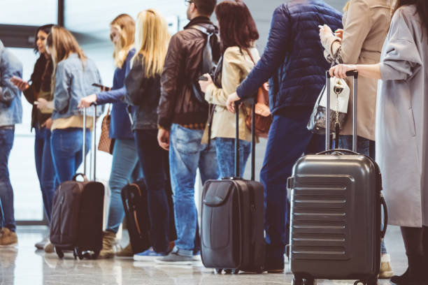 Group of people standing in queue at boarding gate Shot of queue of passengers waiting at boarding gate at airport. Group of people standing in queue to board airplane. waiting in line stock pictures, royalty-free photos & images