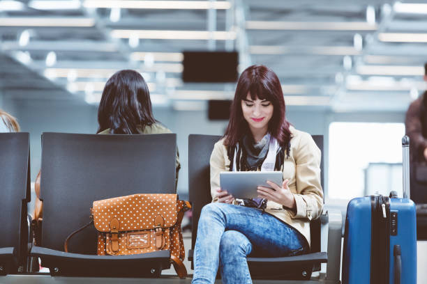 istock Young woman using tablet pc at airport 815723480