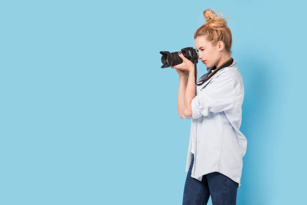 istock Young blonde photographer is taking a photo. 815726318