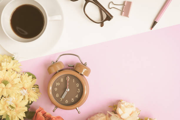 istock Flat lay coffee glasses and clock with pens and flowers 815733896