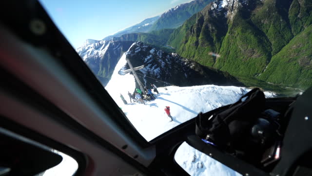 View out of helicopter cockpit over mountains at sunrise