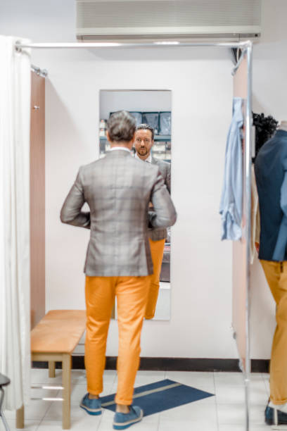 Young man in a fitting room Young man in a fitting room fitting room stock pictures, royalty-free photos & images