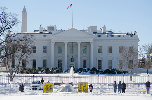 White House, North Portico, after a snow storm. The yellow signs belong to the Peace Vigil, which has occupied a space across the street from the White House since the early 1980s.