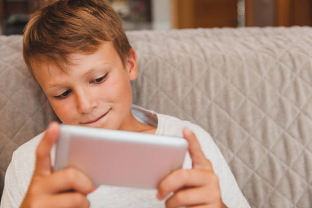 istock Young Boy Playing Games on Smart Phone 815767524