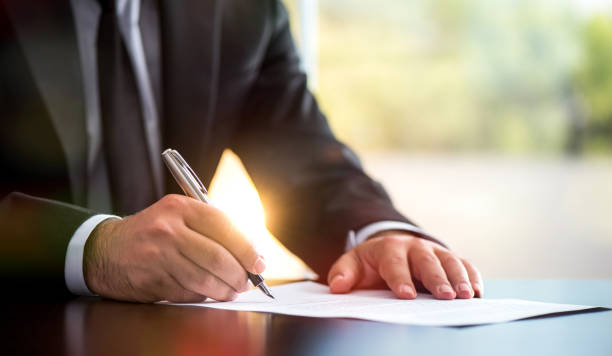 Businessman Is Signing A Legal Document In Office Businessman Is Signing A Legal Document In Office will legal document stock pictures, royalty-free photos & images