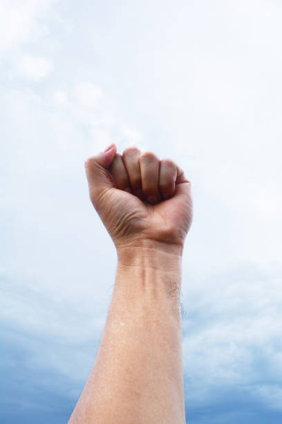 istock the man show his  left punch up to the dark sky 815777760