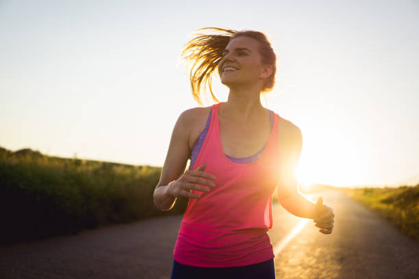 Young woman running through the countryside during the sunset