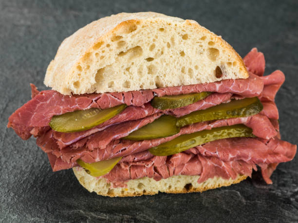 istock Salt Beef or Pastrami With Gherkins in a Ciabatta Bread Roll or Bun 815779294
