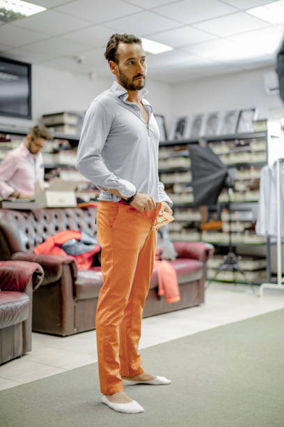 istock Young man is trying  on an orange color trouser 815782112