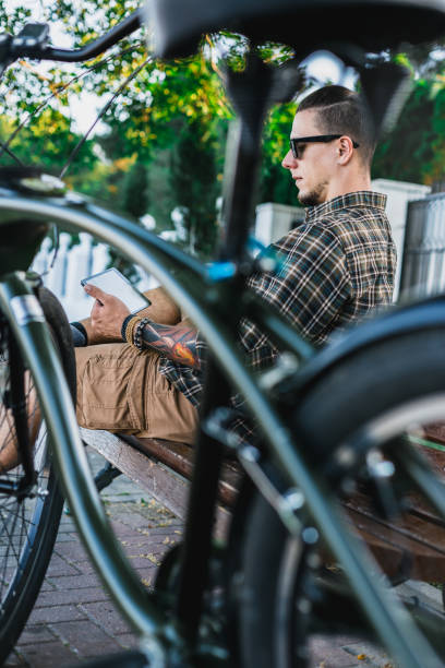 istock Cyclist Man Resting On Bench Near Bicycle And Using Tablet Communication Connection Digital Devices Technology Concept 815783392