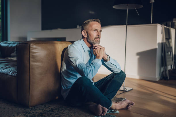 pensive handsome bearded midaged man sitting on floor