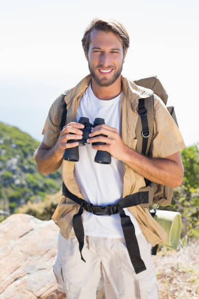istock Handsome hiker holding binoculars on mountain trail 815844512
