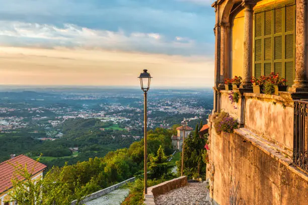 Picturesque view of the final part of the sacred road with the 14th chapel, Varese, on the horizon the city of Milan, at dawn. Sacro Monte of Varese is located in the Regional Park Campo dei Fiori. In 2003 entered from UNESCO in list of World Heritage
