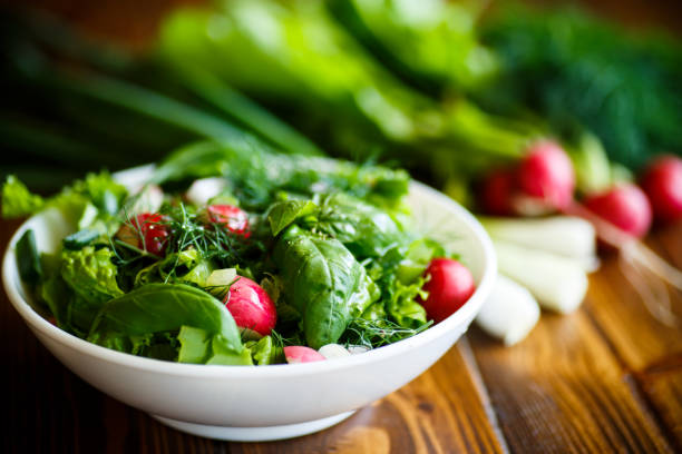 Spring salad from early vegetables, lettuce leaves, radishes and herbs Spring salad from early vegetables, lettuce leaves, radishes and herbs in a white bowl Garden Salad stock pictures, royalty-free photos & images