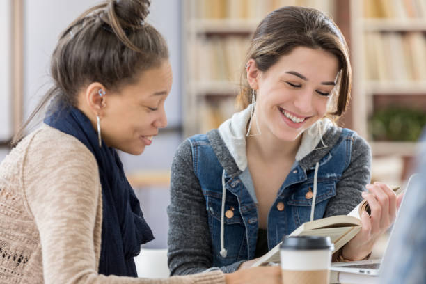 istock College girls read book in college library 815897916