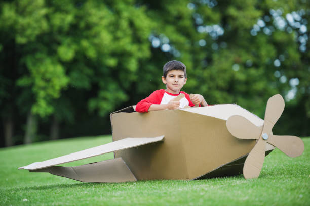 istock Cute little boy sitting in toy plane while playing in park 815903742