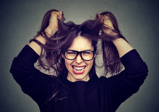 istock Closeup portrait stressed angry woman pulling hair out screaming 815909560