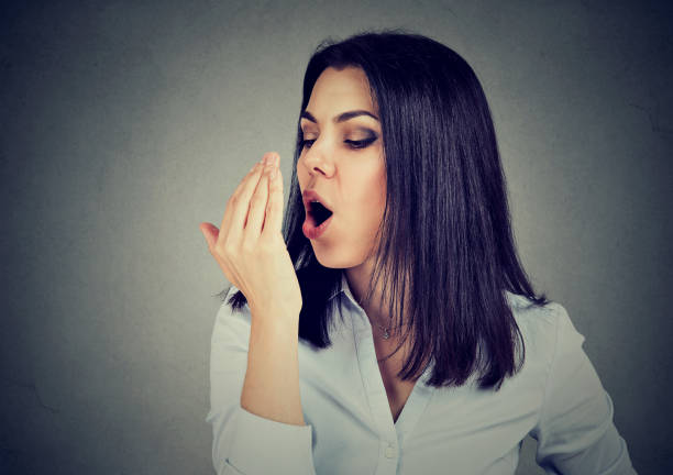 istock Woman checking her breath with hand. 815909760