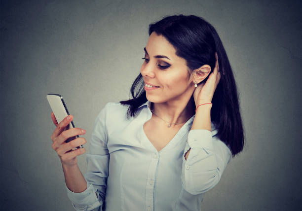 istock Smiling woman reading text message on smart phone having a pleasant conversation 815910016