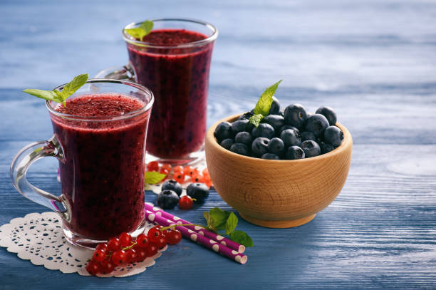 istock Healthy beverage - blueberry smoothie on wooden background. 815910112
