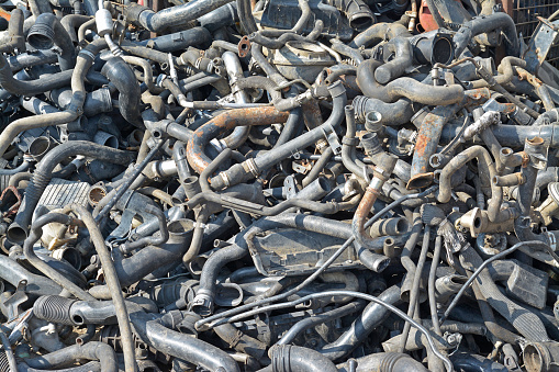 a heap of car engine pipes in a junkyard