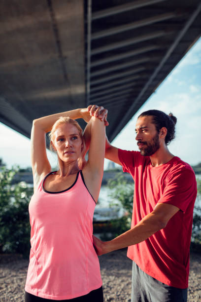 istock Woman Exercising With Personal Trainer Outdoors 815931554