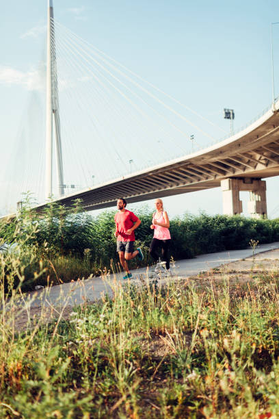 istock Woman Jogging With Personal Trainer Outdoors 815931894