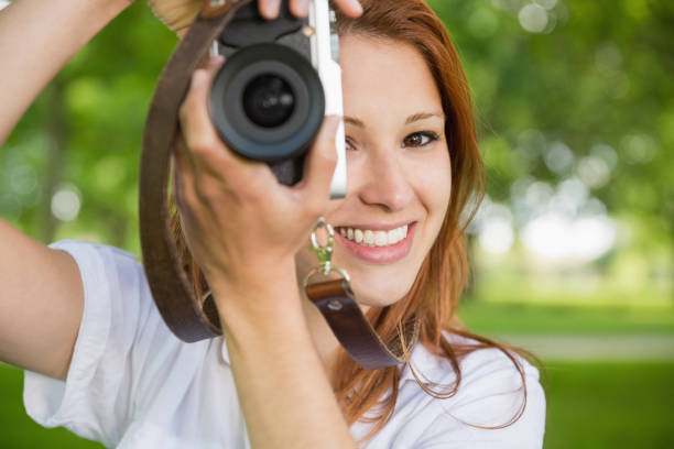 istock Pretty redhead taking a photo in the park 815934154