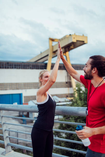 istock Woman Exercising With Personal Trainer Outdoors 815939246