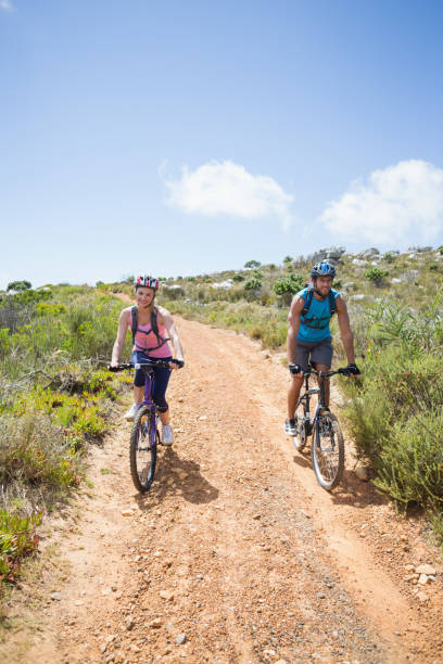 istock Fit couple cycling up mountain trail 815975040
