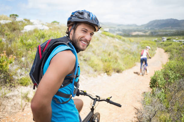 istock Fit couple cycling on mountain trail man smiling at camera 815982256