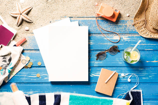 istock White blank magazine on blue wooden platform with summer accessories 815991476