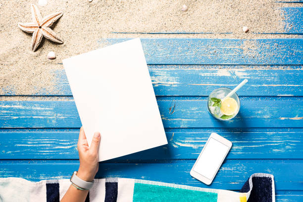istock Woman hands holding white blank magazine on beach towel 816017656