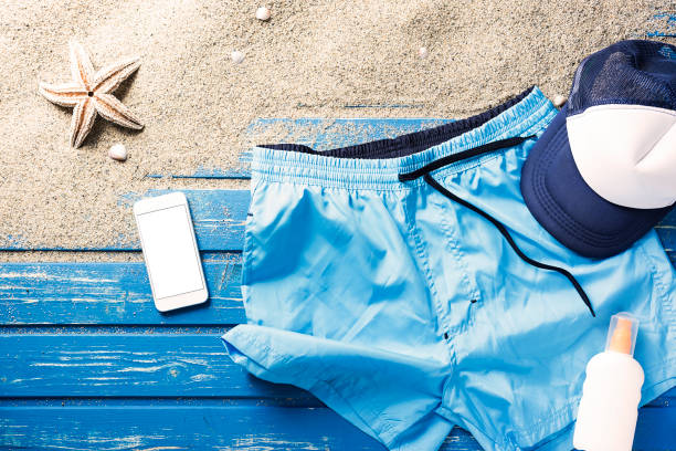 istock Flat lay shot, swim shorts and phone on blue beach platform 816030508