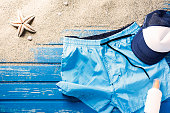 Flat lay shot of swim shorts on blue wooden beach platform