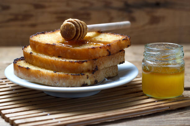 istock Three fried toast with honey on a wooden background 816076642